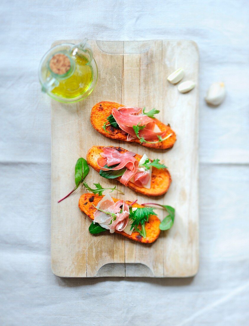 Tomato and garlic french toast with raw ham and lettuce