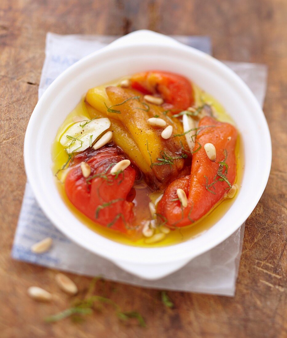 Salat mit marinierten Paprika in Olivenöl, Pinienkernen und Knoblauch