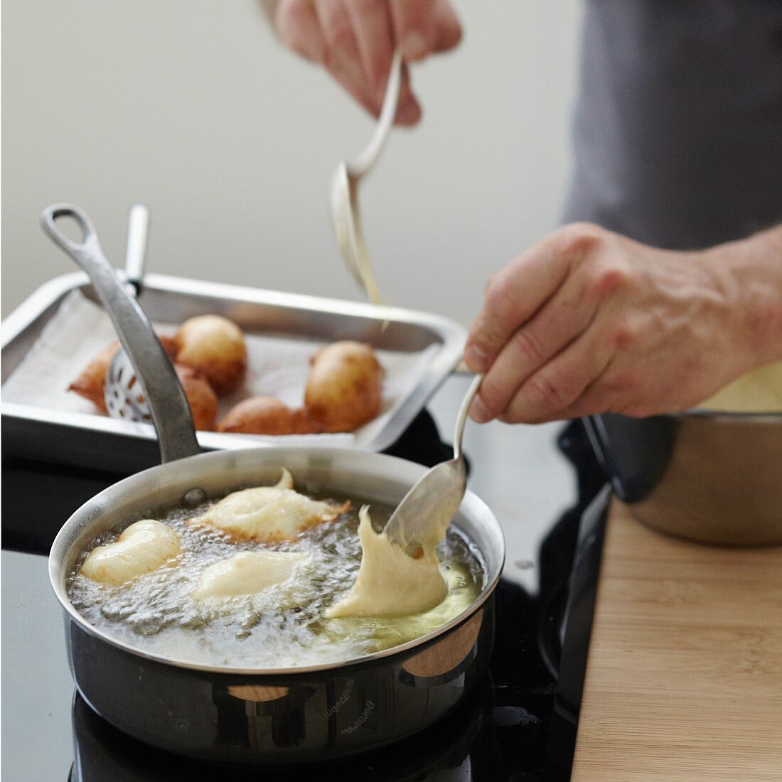 Deep-frying spoons full of Croustillons batter in hot oil