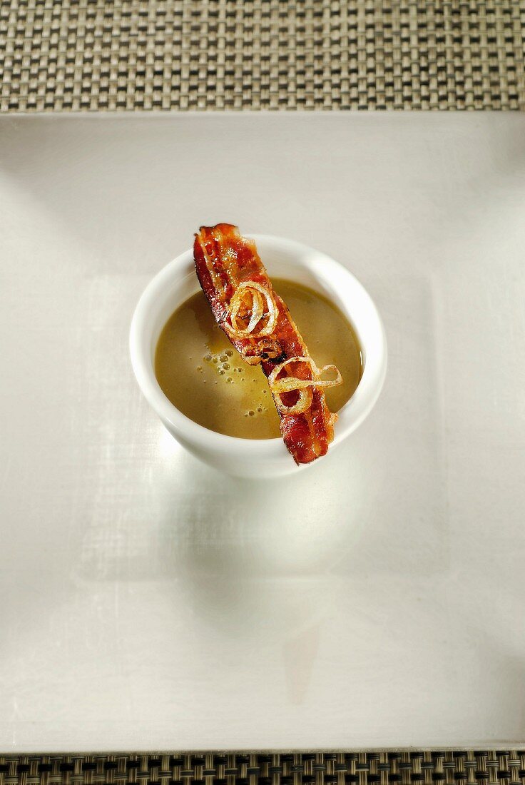 Linsensuppe mit Curry, gegrillten Zwiebeln und Speck