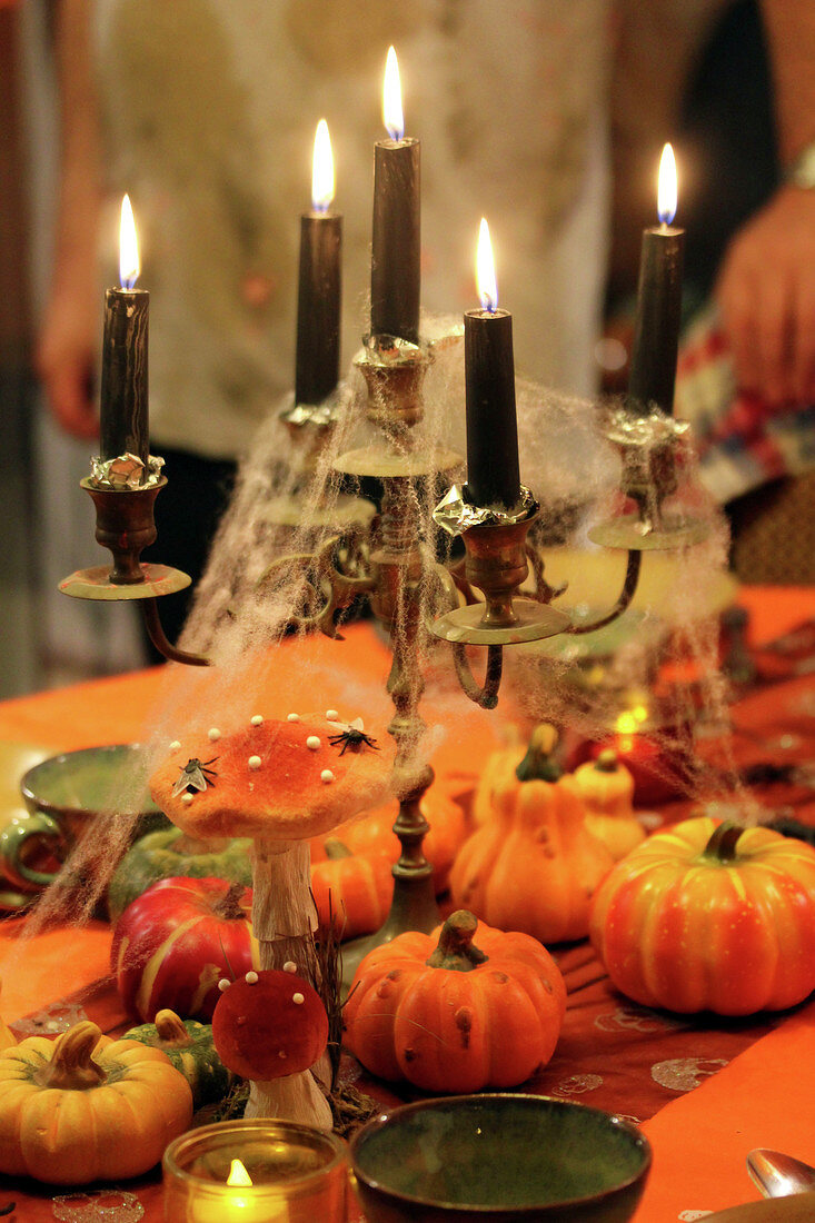 Gedeckter Halloween-Tisch mit Kerzen und Kürbissen