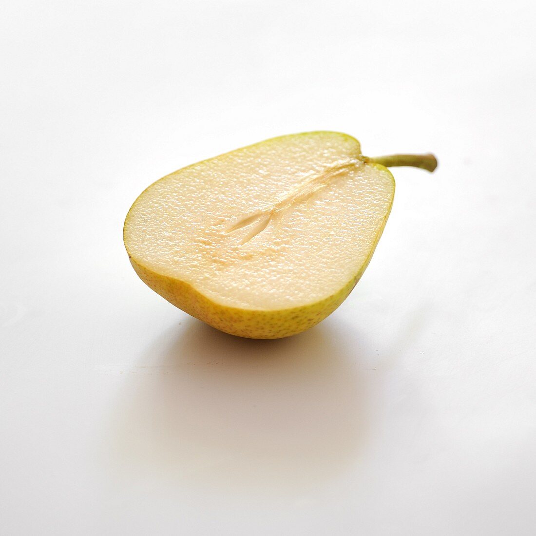 Half a Guyot pear on a white background