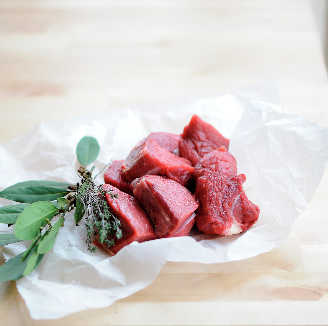 Pieces of raw beef and a bouquet garni