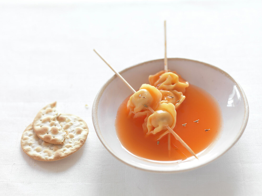Beef tortellinis brochettes with carrot and cumin broth