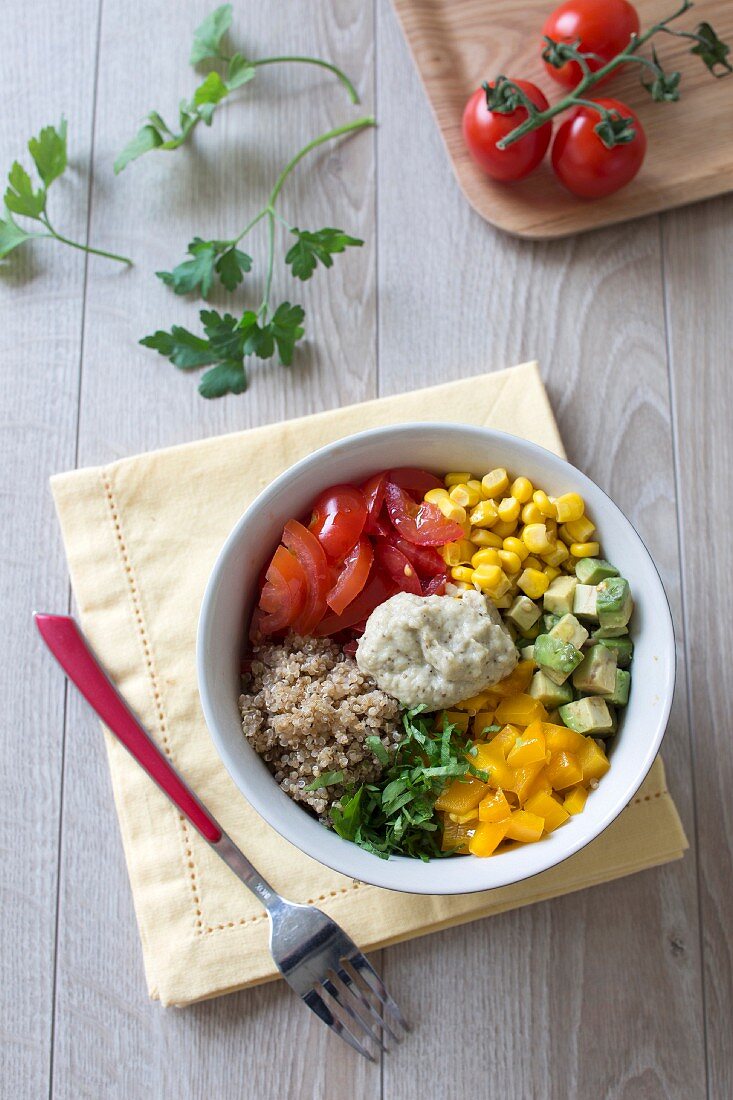 Tomato, avocado, sweet corn, mango and aubergine caviar Buddha bowl