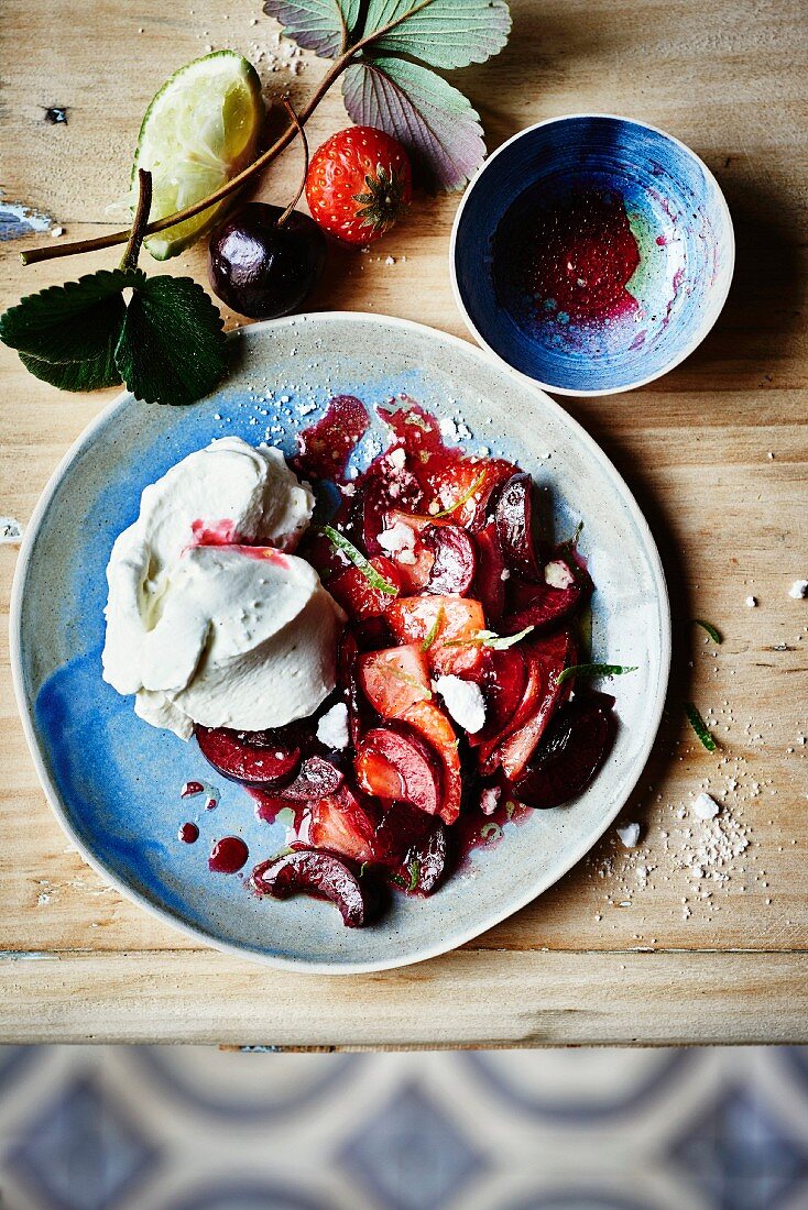 Pan-fried strawberries and cherries with pepper, lime-flavored oil and whipped cream