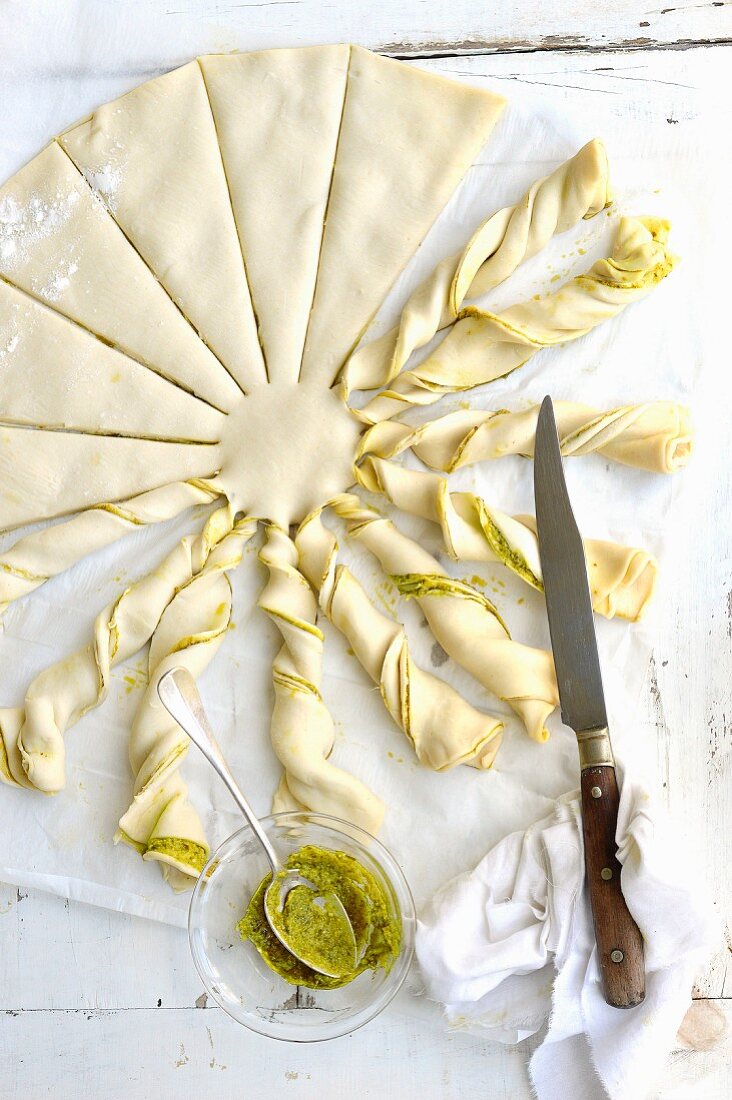 Twisting slices of the filo pastry with the pesto to shape the sun beams
