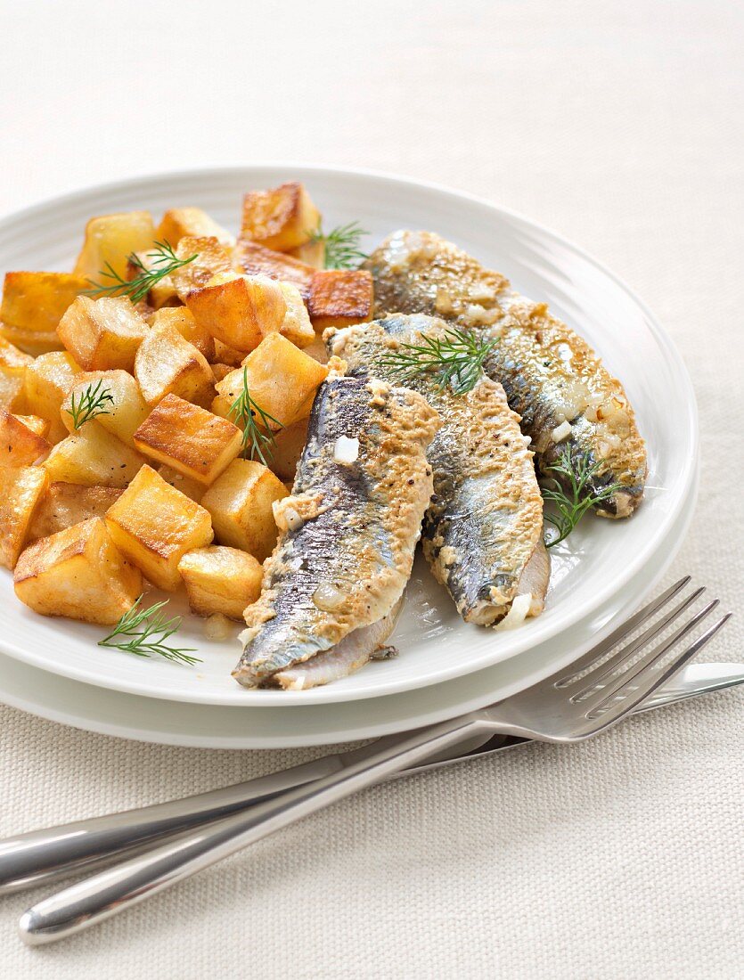 Pan-fried sardines coated in mustard and sauteed potatoes
