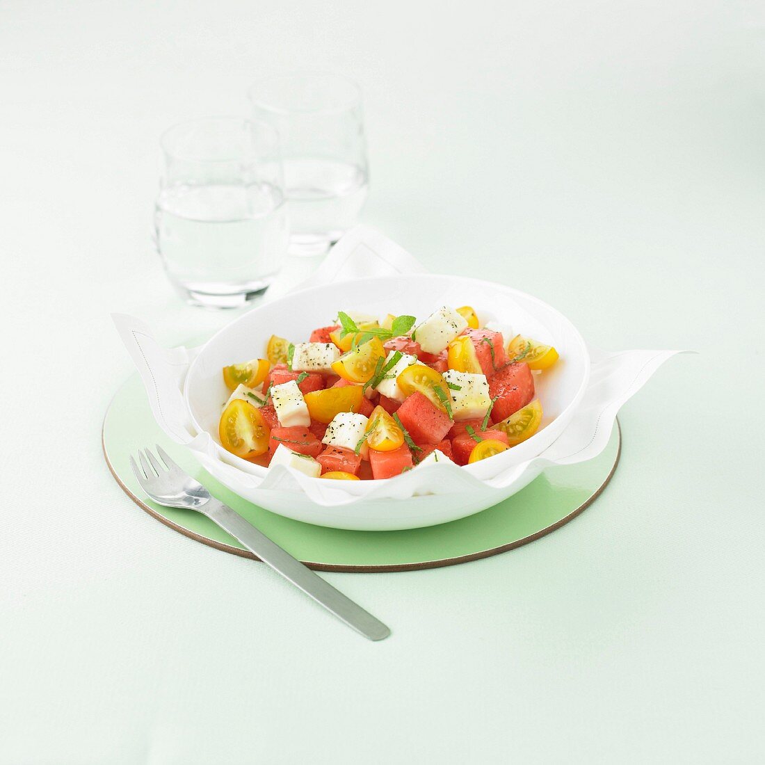 Salat mit Wassermelone, gelben Kirschtomaten und Mozzarella
