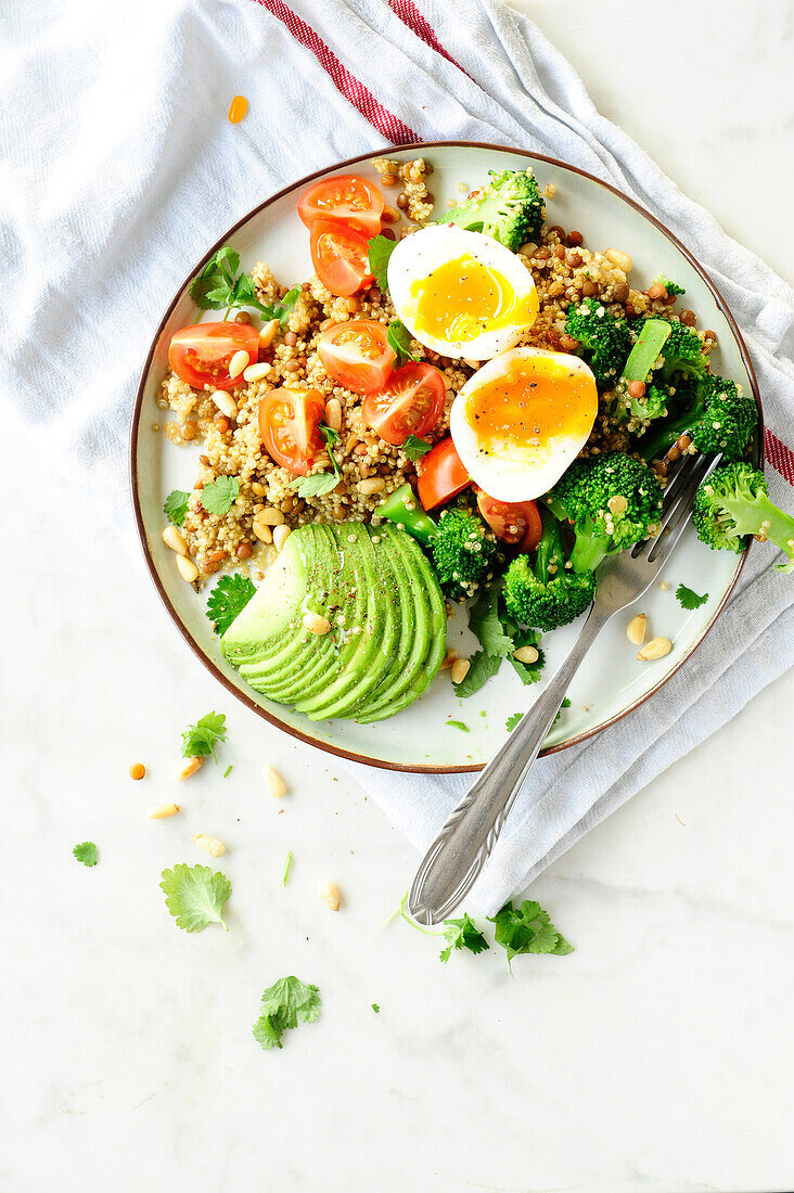 Quinoa salad with broccoli, lentils, avocado, tomatoes and egg (vegetarian)