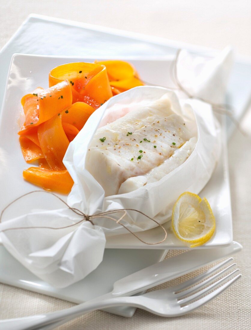 Lemon-flavored cod papillote and thin strips of carrots with honey