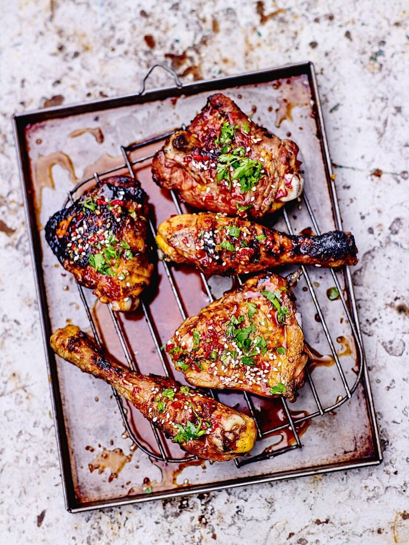 Grilled chicken drumsticks and thighs, spicy soy marinade, chilli paste and sesame seeds