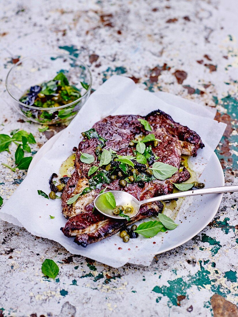 Gegrilltes Lammfleisch, Sauce mit Kapern, Oliven und Basilikum