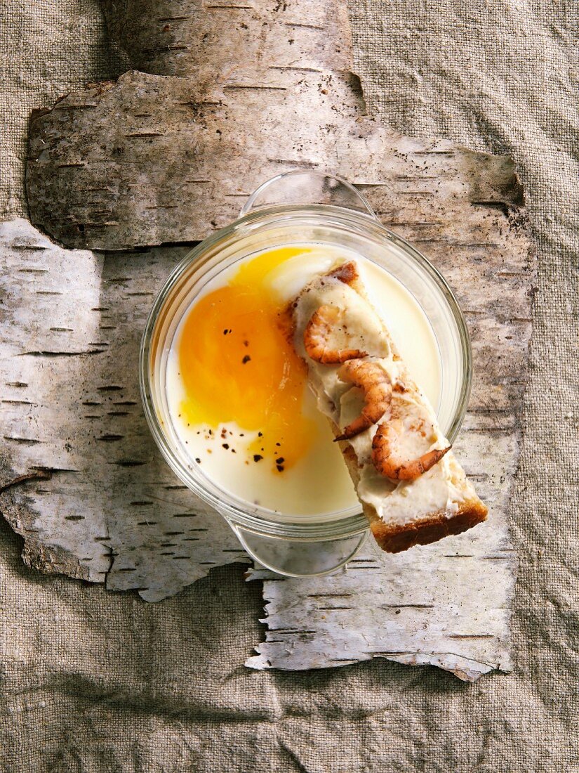 Coddled egg with toasted finger of bread with brown shrimps