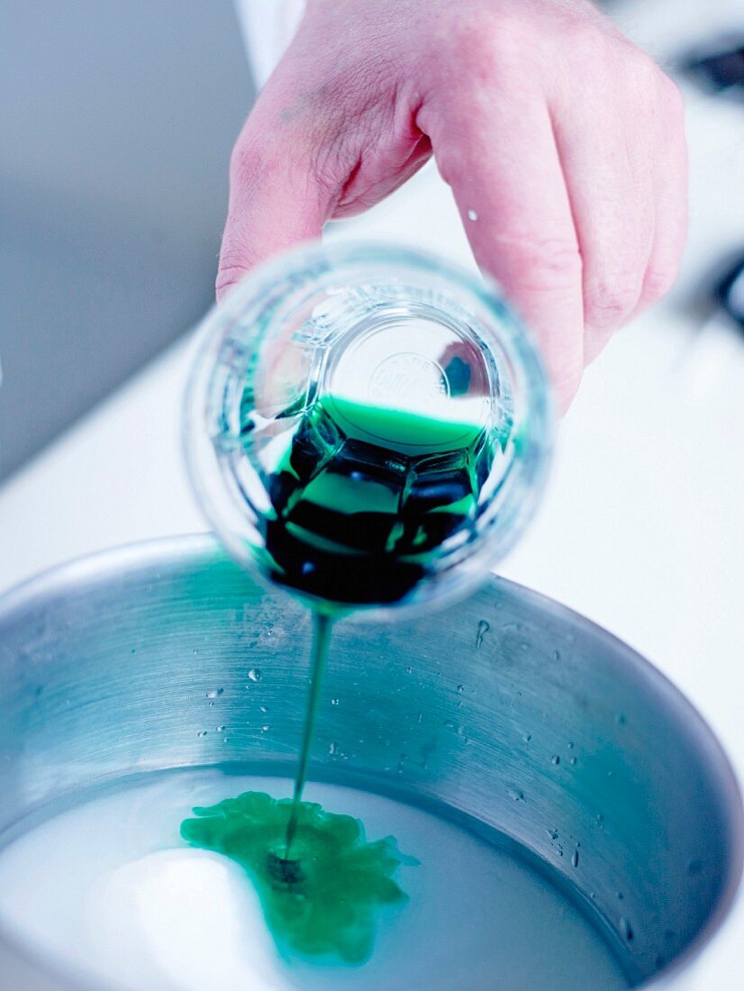 Pouring the mint syrup into the mixed sugar and water