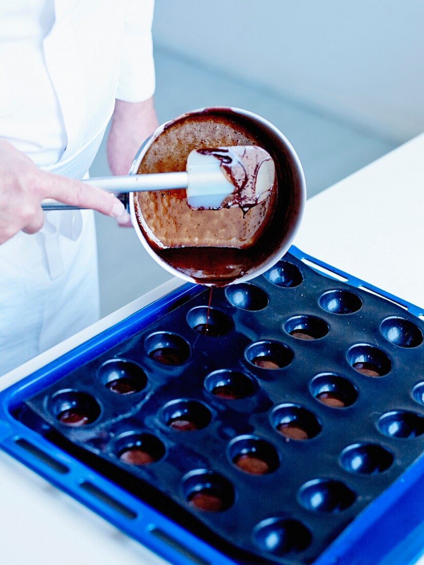 Pouring the hot preparation in a small round silicone molds