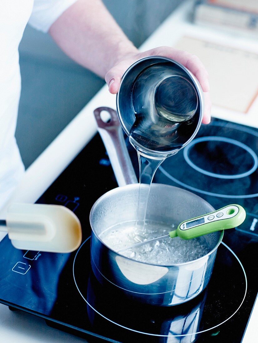 Bergamotten-Berlingots herstellen: Zucker, Wasser und Glukose in einen Kochtopf geben und auf kleinem Feuer erhitzen