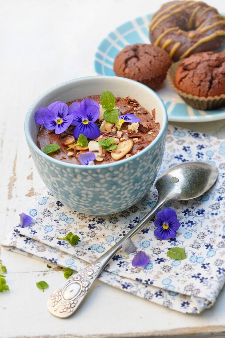 Schokoladenmousse mit Mandeln, Haselnüssen, Stiefmütterchen und Minze, Schoko-Donut und Schokomuffins