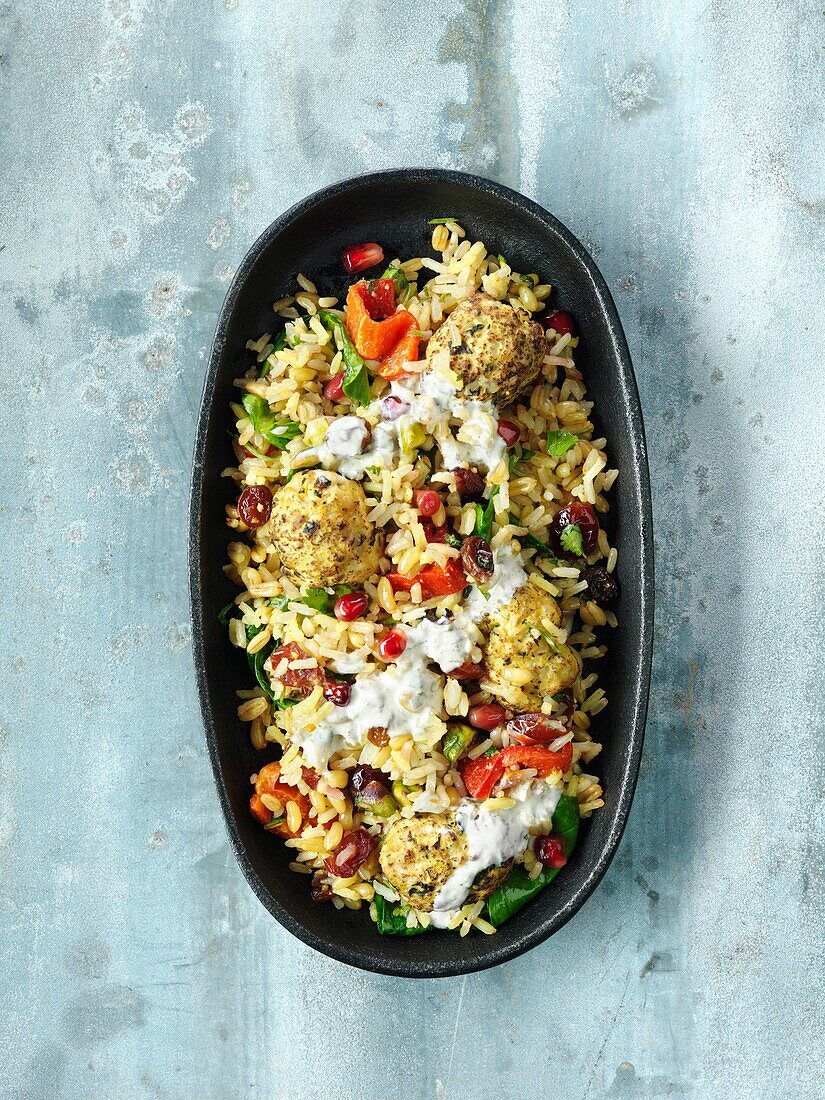 Rice with lamb and chicken dumplings, coriander and pomegranate seeds