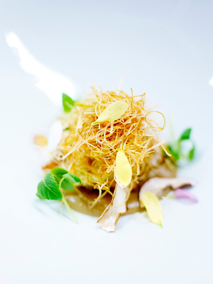 Fried leek nest with flower petals and treacle