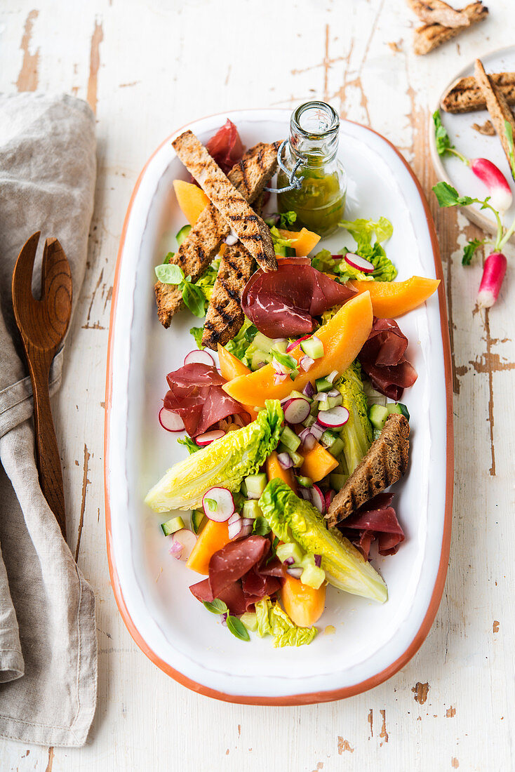 Sucrine, melon, radish, toast and bresaola salad