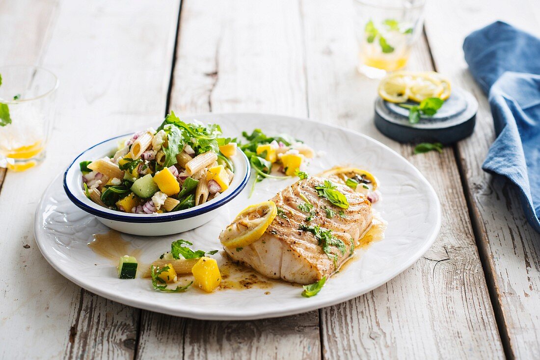 Roasted cod fillet with confit citrus and basil, pasta salad, cucumber, mango and feta