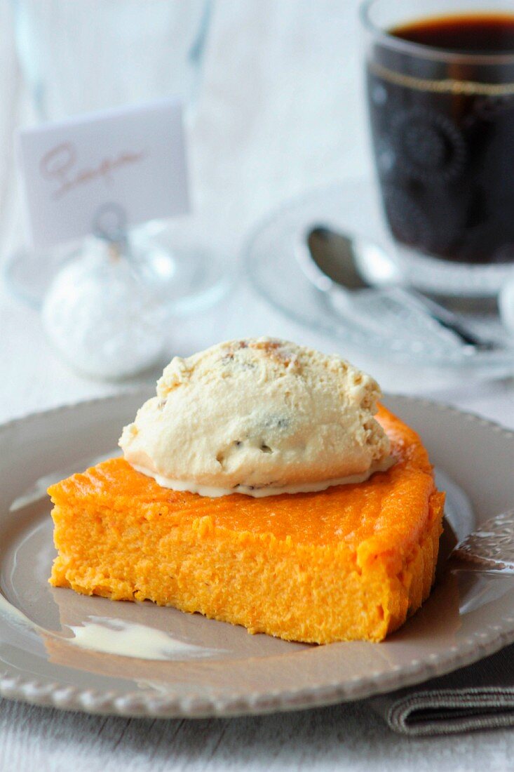 Slice of pumpkin pie topped with a scoop of exotic fruit ice cream