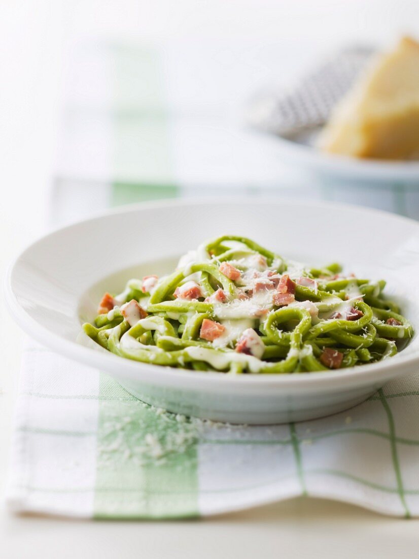 Spinach pasta in creamy parmesan and thinly diced ham sauce