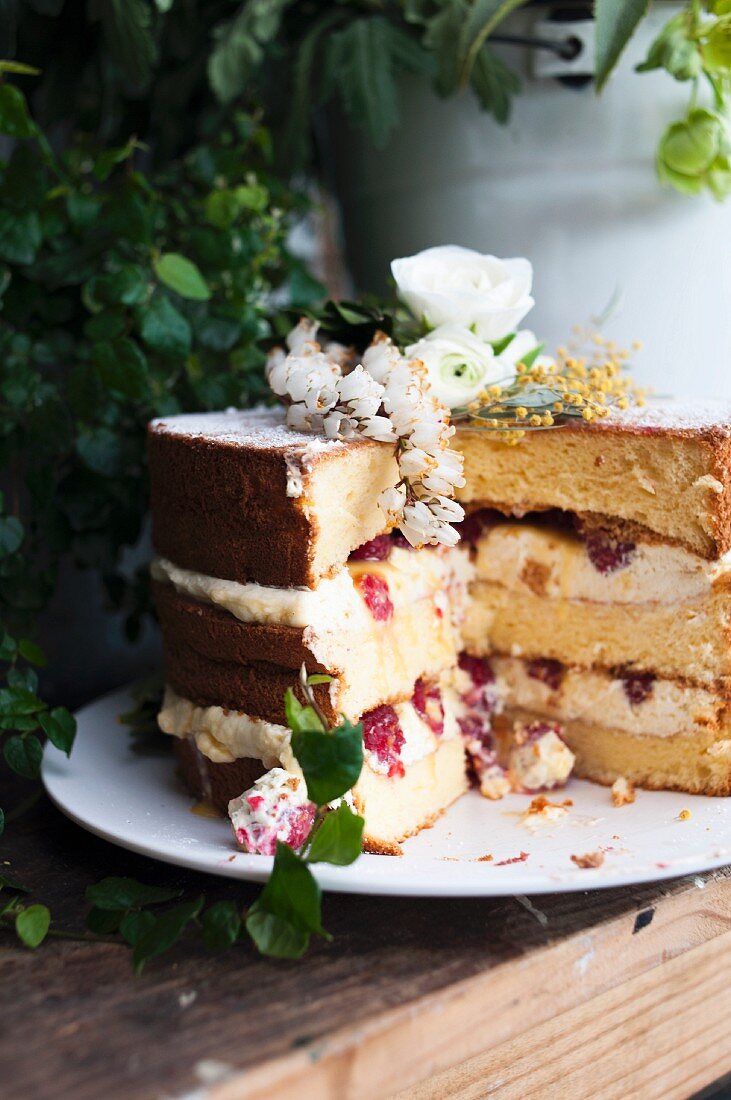 Naked Cake mit Kakao, Himbeeren und Blumendeko