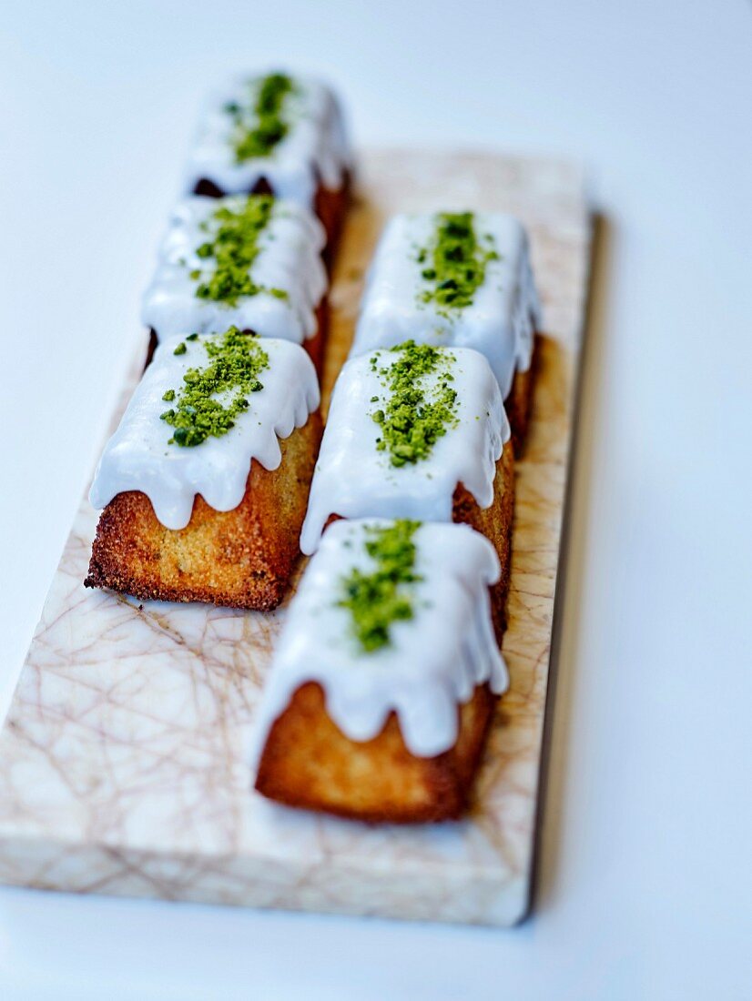 Small coconut cakes with vanilla icing and green matcha tea powder