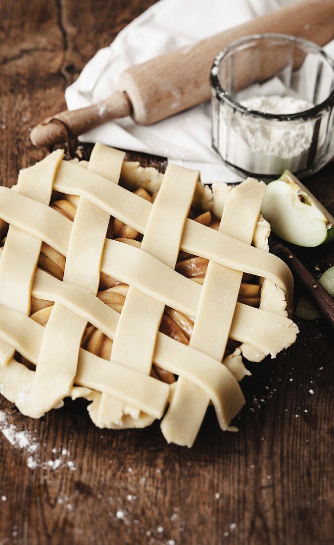 Covering the apple pie with criss-cross strips of uncooked pastry