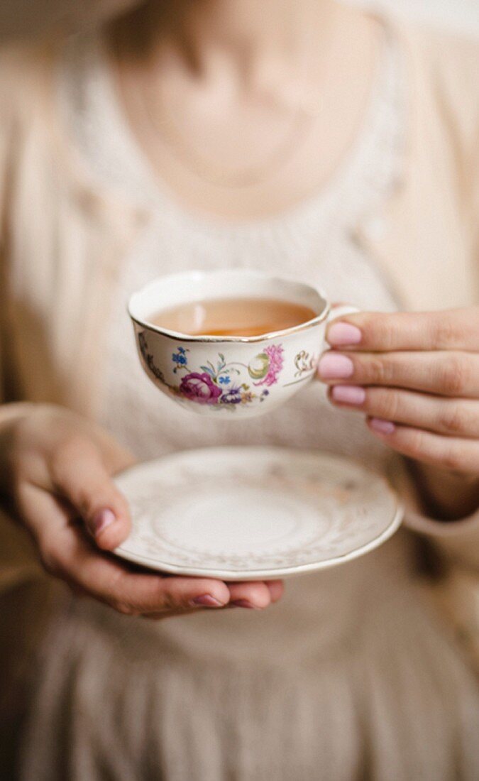 Woman holding a china cup of tea