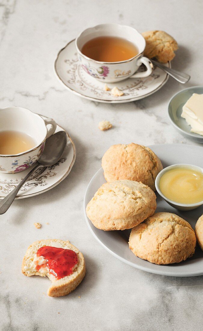 Afternoon tea with scones, butter, strawberry jam and lemon curd