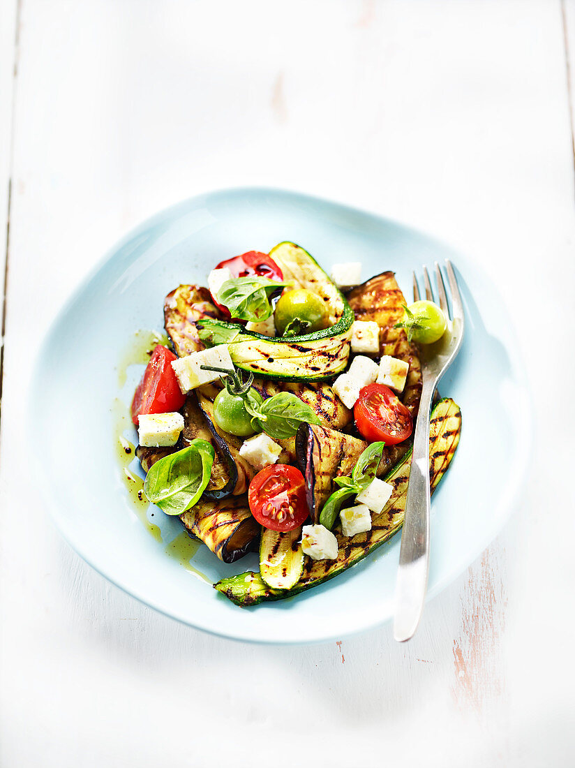 Grilled summer vegetables with diced cheese and basil