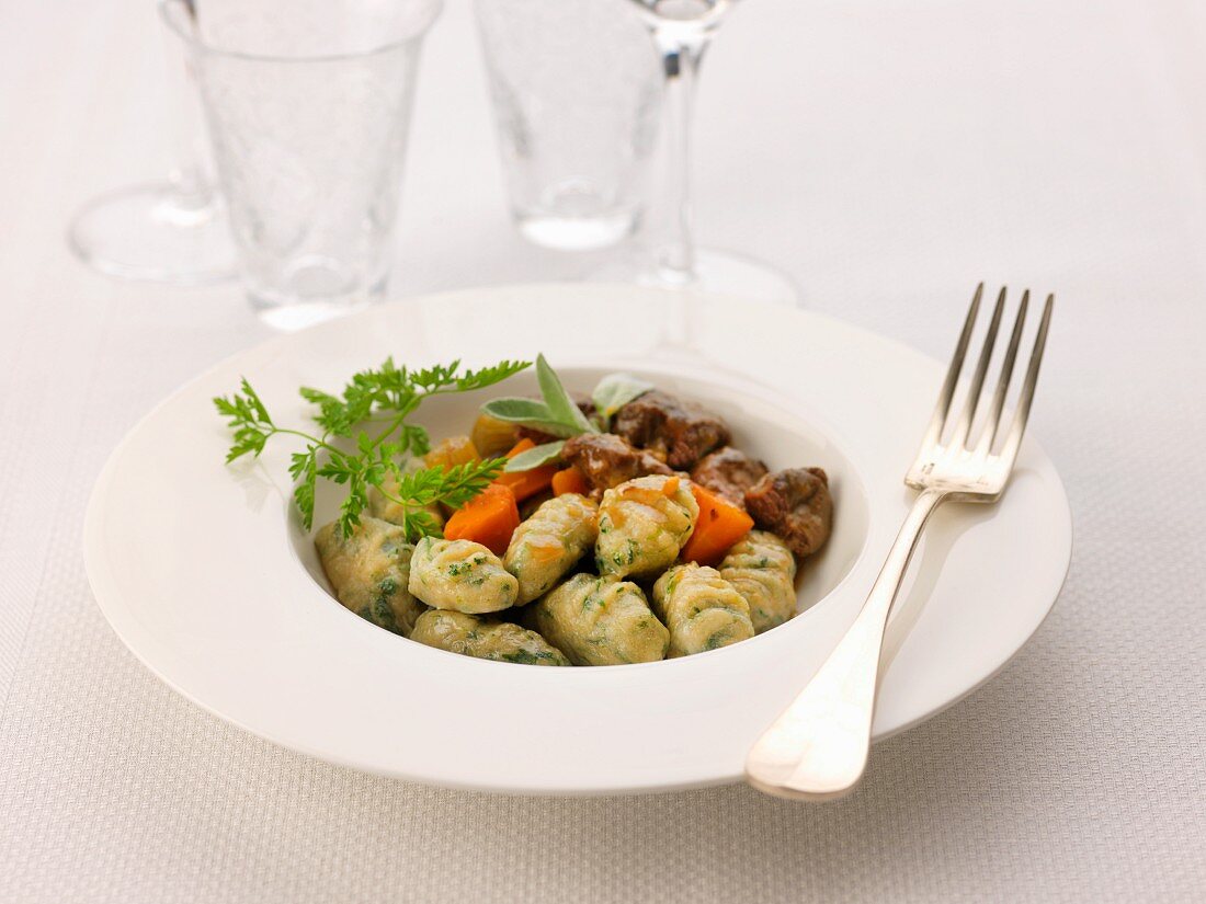 Potato and herb gnocchis and pieces of Botifarra with carrots