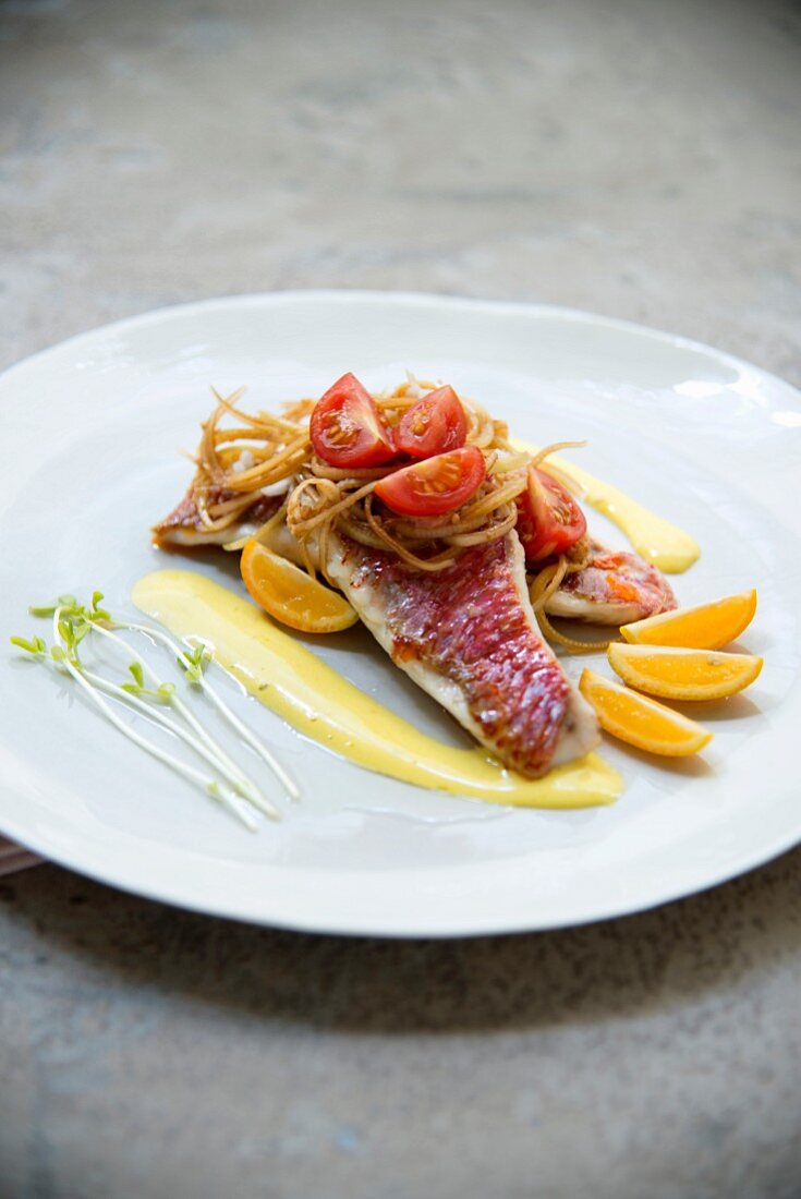 Red mullet fillets with honey and onions, tomatoes and kumquat coulis