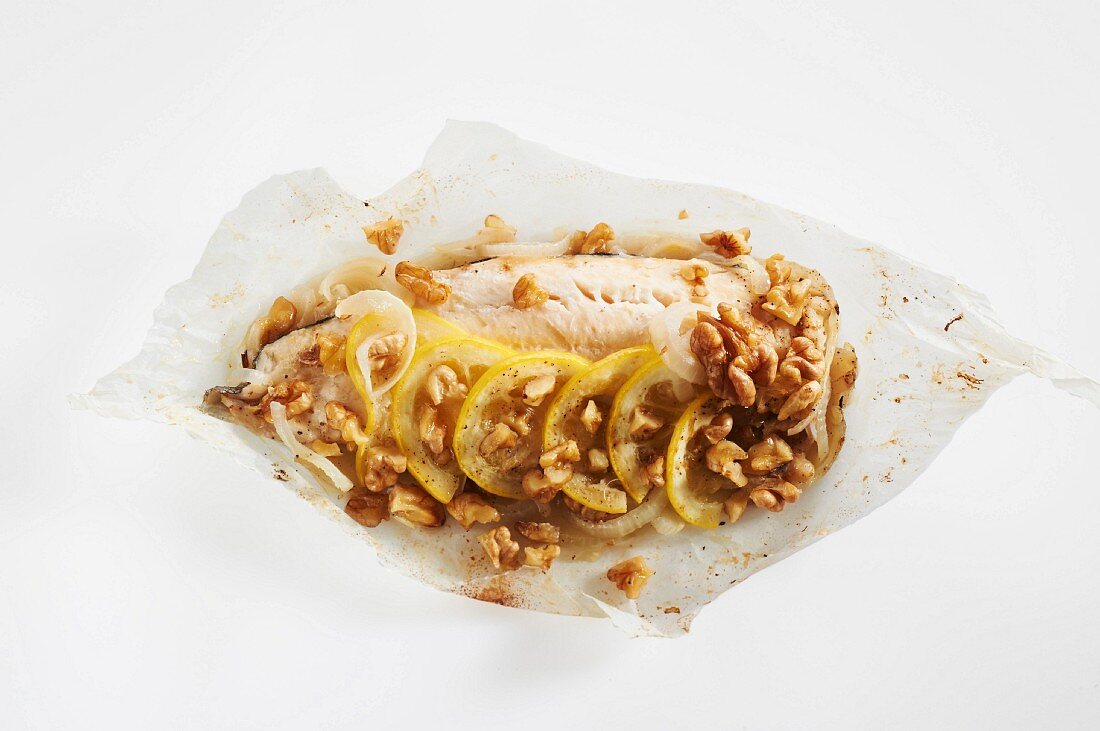 Trout fillet with lemon, onions and walnuts cooked in wax paper
