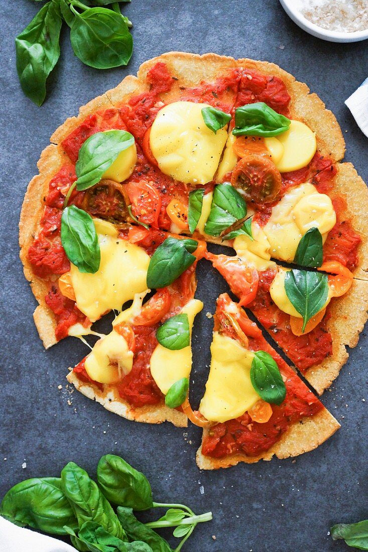 Pizza mit Kichererbsen, Tomaten, Käse und Basilikum