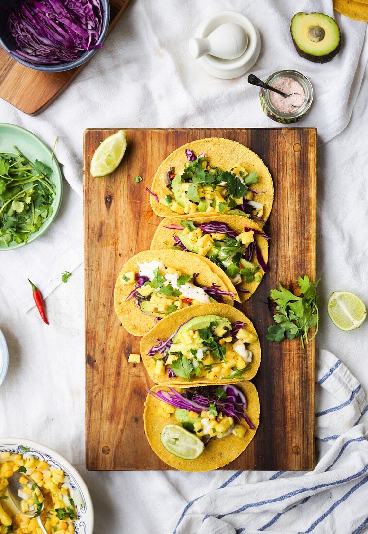Corn tacos garnished with avocado and red cabbage