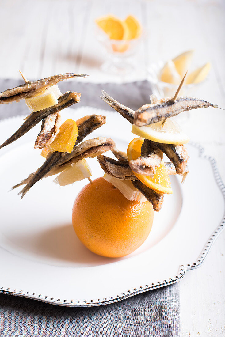 Fried anchovy and citrus fruit brochettes