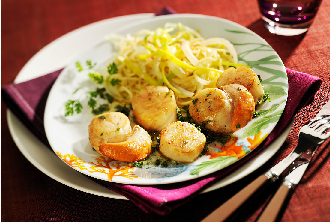Scallops with parsley butter, spaghettis and thinly sliced leeks