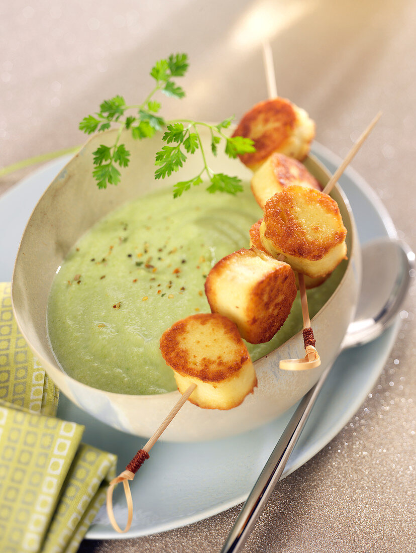 Cream of pea soup with quenelle brochettes