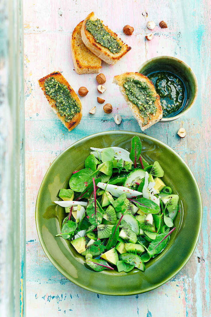 Spinach, kiwi, cucumber, avocado and beetroot sprout salad, pesto on toast