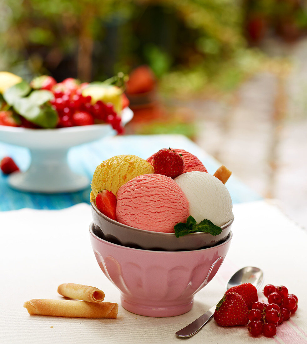 Bowl of different flavored scoops of ice cream and fresh fruit