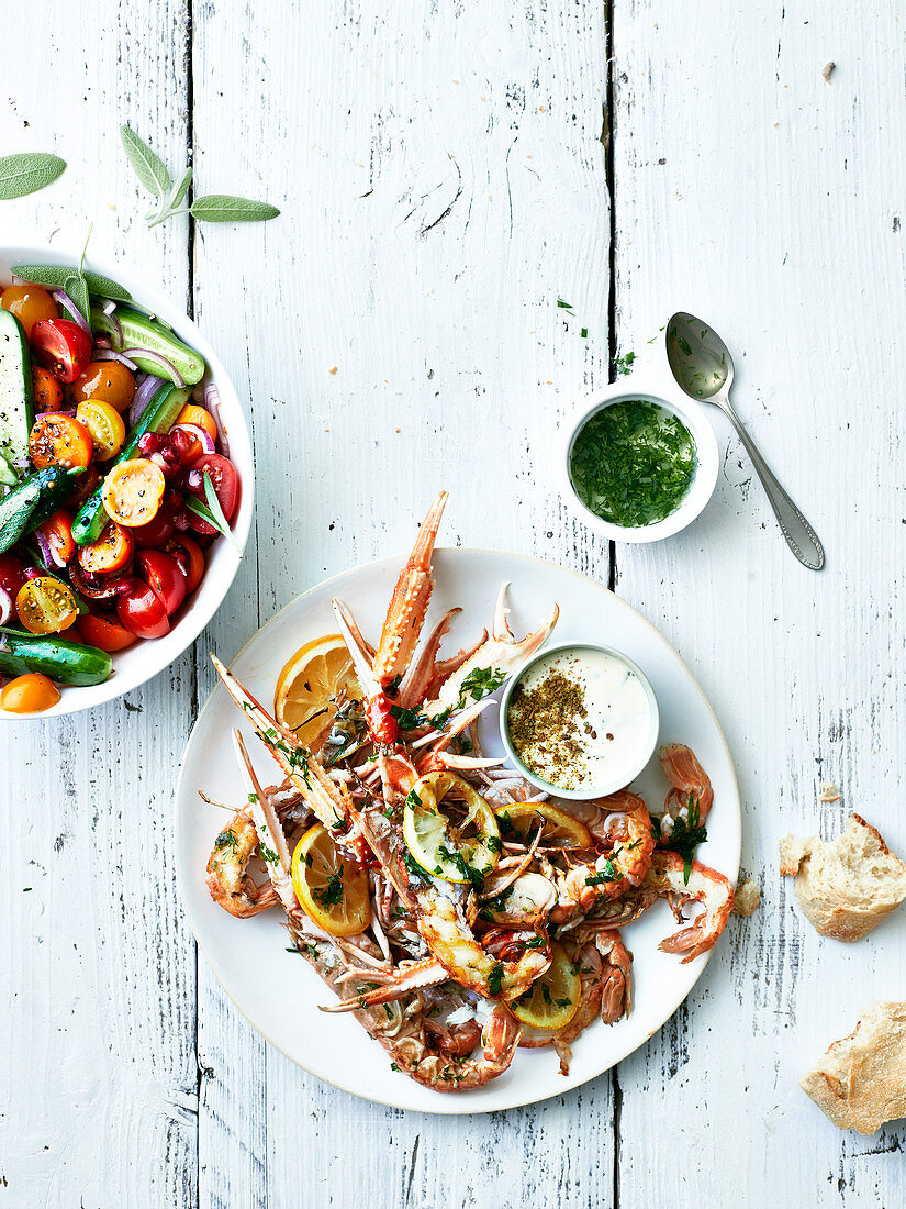 Roasted scampi with herbs and lemons served with cherry tomato salad with mini cucumbers