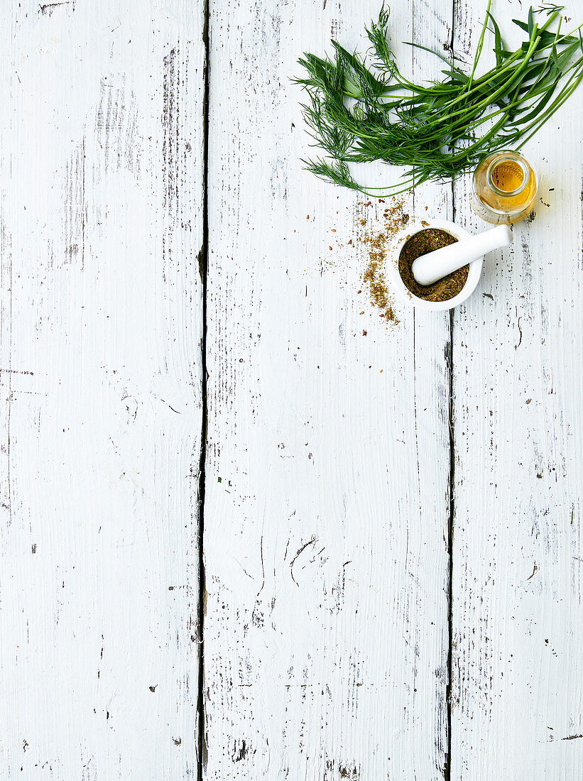 Spicies in a mortar,bottle of oil and fresh herbs on a white background