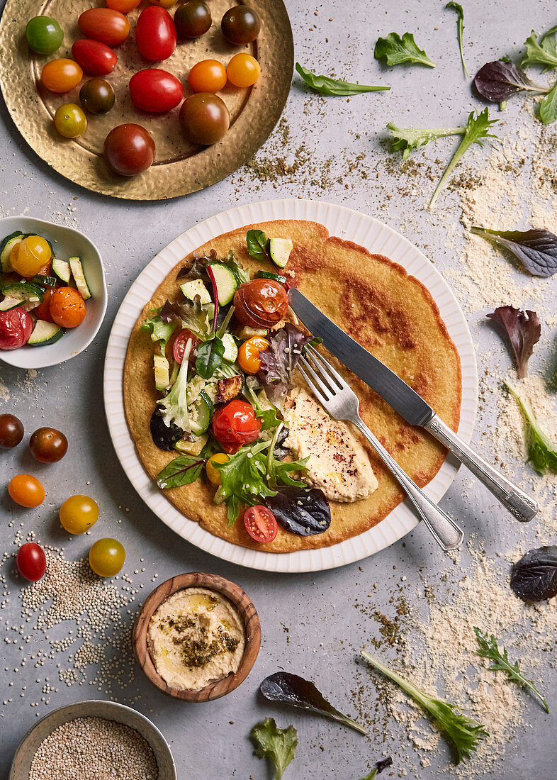 Farinata (Pfannkuchen aus Kichererbsenmehl, Italien) mit Zucchini, Tomaten, Hummus und Salat