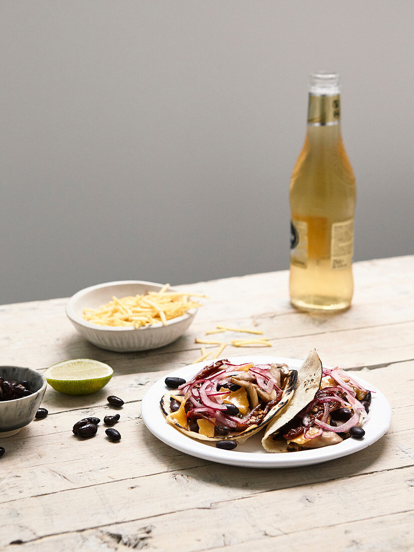 Wheat tortillas garnished with mushrooms, black beans, red onions and Mimolette cheese