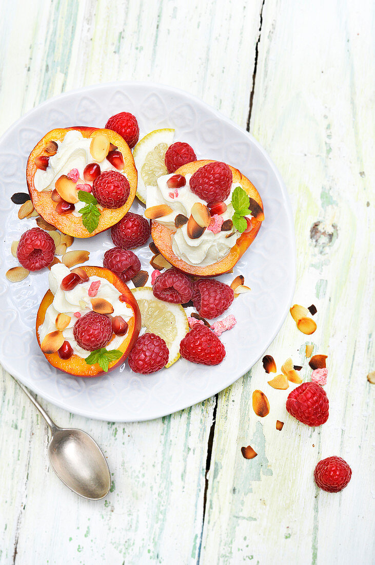 Nektarinen mit Schlagsahne, Himbeeren, Mandeln und Granatapfel