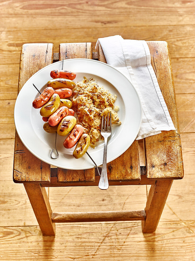 Spiesschen mit Cocktailwürstchen und Kartoffeln, dazu Sauerkraut